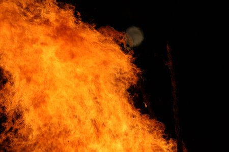 Large bright bonfire with distant moon at night-outdoor energy