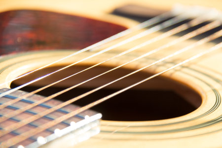 Acoustic guitar with focus on strings, bridge, and sound hole