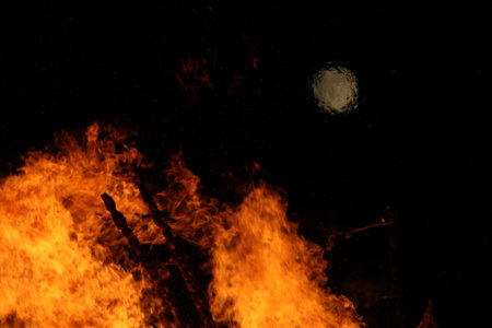Large bonfire with intense orange and yellow flames burning woodの写真素材