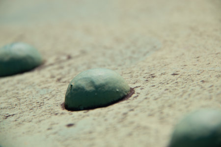 Close-up of green climbing holds on a textured boulder wall surface with shallow depth of fieldの写真素材