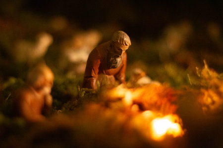Nativity scene figurines in warm candlelight with defocused background and moss baseの写真素材