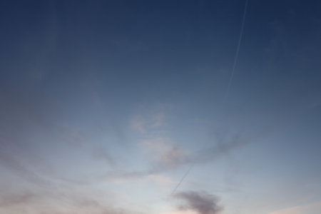 Clear blue sky with airplane contrails and faint evening clouds in Haag in Oberbayern, Germany
