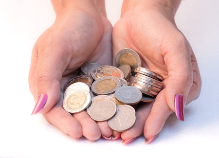 a lot of silver coins in two hands of a woman,on white background 