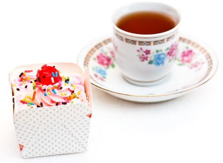 The sweets cupcake and tea are refreshments on white backgroundの写真素材