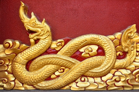 This golden dragon sculpture on the wall の写真素材