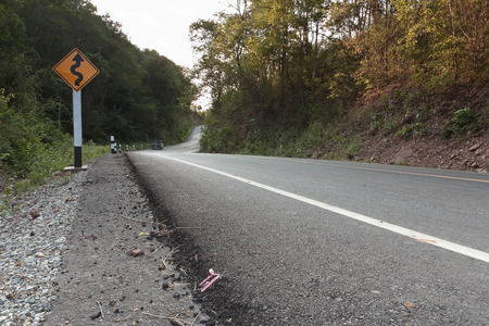 Warning sign.On the road ahead is the right winding road in the countryside of Thailand.の写真素材