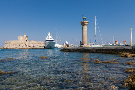 Statue Deer and hound and columns in Mandraki harbor. On background Santa Claus Fortress. Place where was statue, colossus from Rhodes. Symbolic gate to the harbor.のeditorial素材