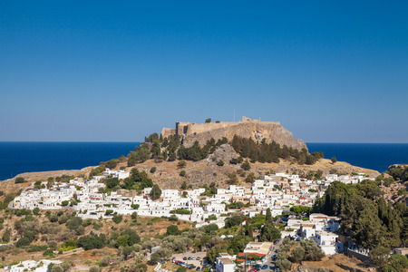 Lindos town at the foot of the mountain. Acropolis of Lindos is located on a hill above the town. Bay and harbor with beach.のeditorial素材