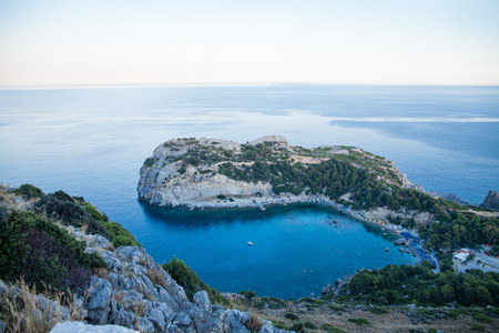 View from top on Anthony Quinn Bay and beach, Rhodes in Faliraki, Greece. Happy girl Raising One Hand. Beautiful beach and bay on the island of Rhodes. の写真素材
