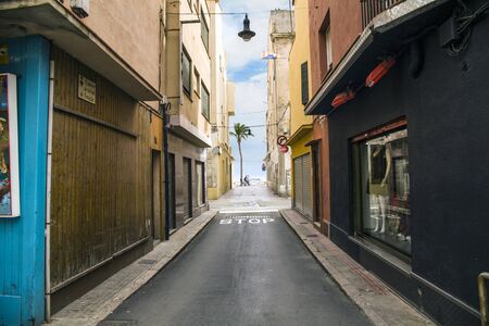 Shops and cafes near the narrow streets of Lloret de Mar. Downtown of Lloret, Spain. Tourists walking the streets of the city.のeditorial素材