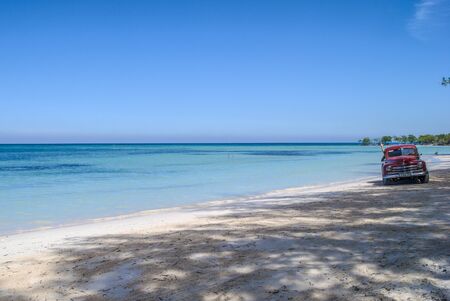 Car  and Shadow of palm on the beach of Cayo Jutias in Cuba. Boat and blue sea have a rest on the...