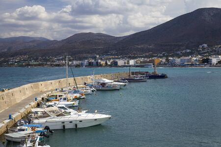 The harbor wharf in Hersonissos, Crete. Port with fishing boats and sailing boats on the Greek island.のeditorial素材