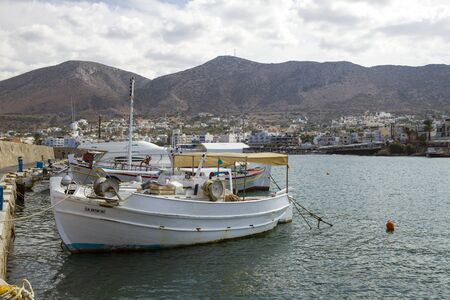 The harbor wharf in Hersonissos, Crete. Port with fishing boats and sailing boats on the Greek island.のeditorial素材