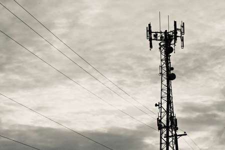 A transmission tower with electric cords in a cloudy skyの写真素材