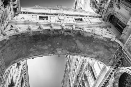 Old historic bridge in heart of romantic Venice, Italy. Monochrome gondola view under the bridge.の写真素材