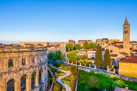 A breathtaking aerial view of Pula Arena in Croatia, showcasing the well-preserved Roman amphitheater surrounded by the historic city center, featuring the charm of this townの写真素材