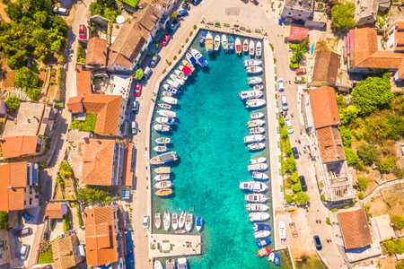 A breathtaking top-down aerial view of the marina in Stomorska on Solta Island, Croatia, showcasing neatly arranged boats, capturing the essence of Mediterranean yachting havenの写真素材