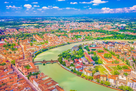 Aerial panorama of Verona, Italy, showcasing the historic city's stunning skyline with the winding River Adige flowing through its heart, surrounded by medieval landmarksの写真素材