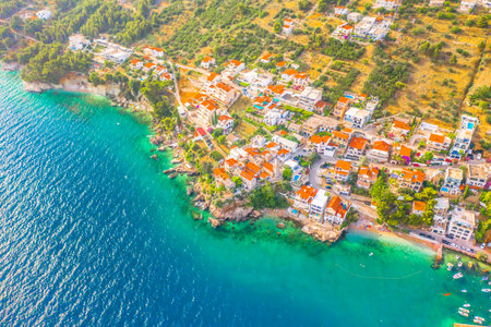 Aerial photograph of the charming coastal village Pisak on the Makarska Riviera, showing waterfront promenade, turquoise sea, pebble beach, and surrounding Mediterranean housesの写真素材