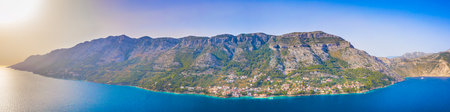 Panoramic aerial view of the picturesque coastal village Pisak on the Makarska Riviera in Croatia, with terracotta rooftops, steep hills, and Adriatic shorelineの写真素材