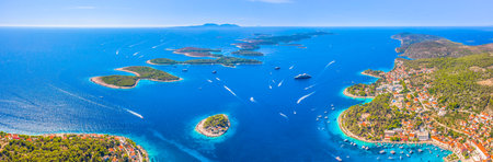 Panoramic aerial view of Hvar Town on the island of Hvar, Croatia, with its historic harbor, and the stunning Pakleni Islands stretching across the turquoise Adriatic Seaの写真素材