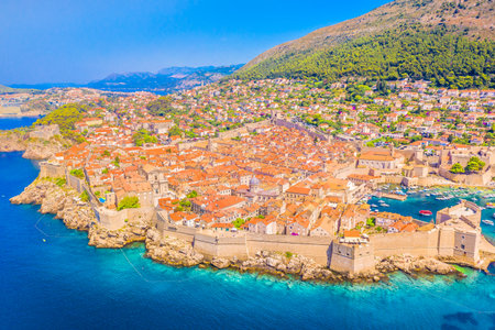 Drone photo of Dubrovnik showing the fortified old town with stone walls, terracotta rooftops, Adriatic coastline, harbor and stunning UNESCO World Heritage medieval architectureの写真素材