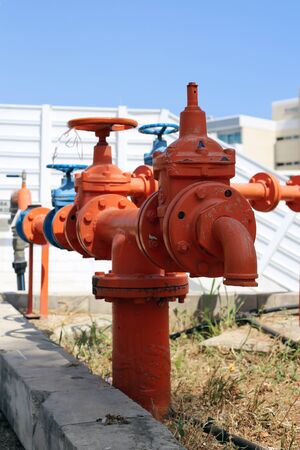 Orange and blue colorful orange and blue water pipes with big vents. In this photo you can see painted colorful pipes and vents in a closeup. Photographed in Cyprus during a sunny summer day.の写真素材