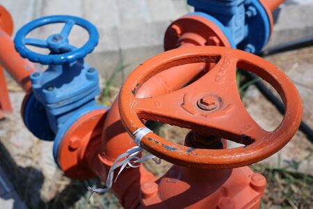 Orange and blue colorful orange and blue water pipes with big vents. In this photo you can see painted colorful pipes and vents in a closeup. Photographed in Cyprus during a sunny summer day.の写真素材