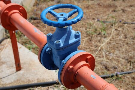 Orange and blue colorful orange and blue water pipes with big vents. In this photo you can see painted colorful pipes and vents in a closeup. Photographed in Cyprus during a sunny summer day.の写真素材