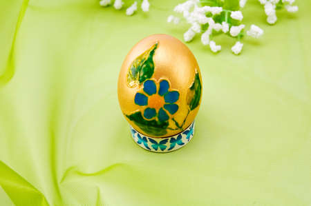 Gold Easter egg a on green background.の写真素材
