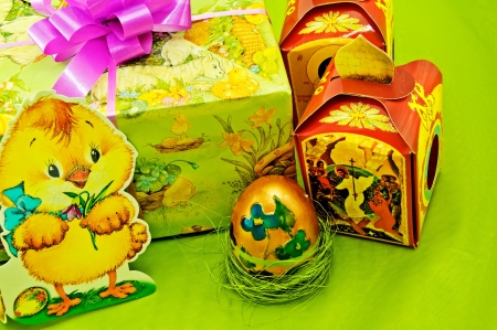 Easter gifts and gold egg a on green background の写真素材