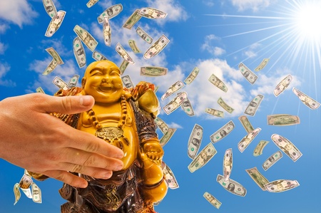 Feng shui. buddha against a blue sky with  falling  dollars.の写真素材