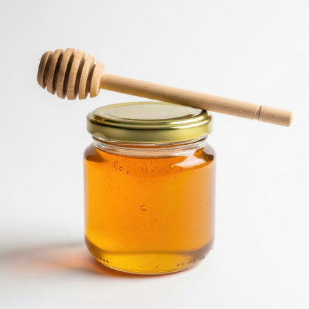Honey jar with dipper isolated on white backgroundの素材