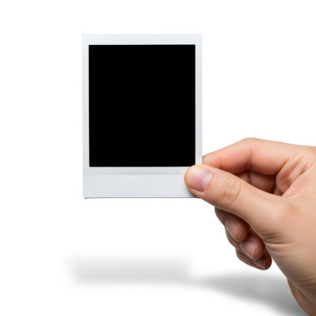Hand holding polaroid frame isolated on white backgroundの素材