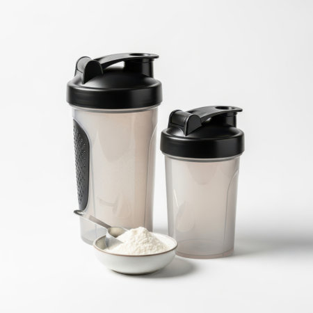 Two protein shaker bottles with powder and spoon isolated on white backgroundの素材