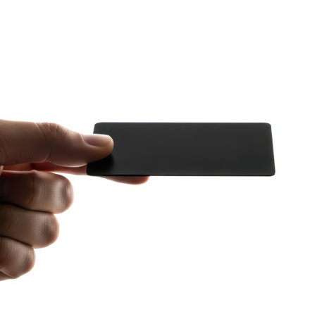 Hand holding black remote control isolated on white backgroundの素材