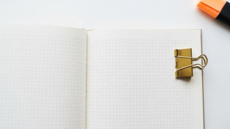 Open notebook with clip and highlighter isolated on white backgroundの素材