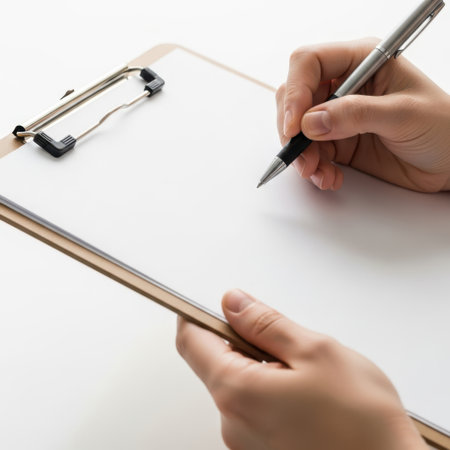 Hands writing on clipboard isolated on white backgroundの素材