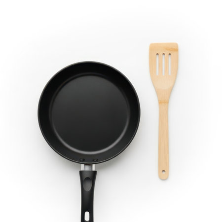 Nonstick frying pan and wooden spatula isolated on white backgroundの素材