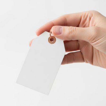 Hand holding price tag isolated on white backgroundの素材