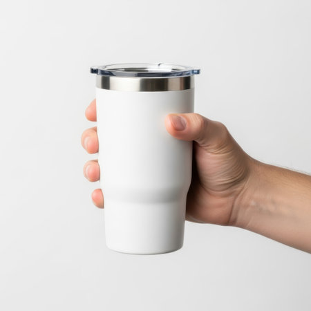 Hand holding white tumbler isolated on white backgroundの素材