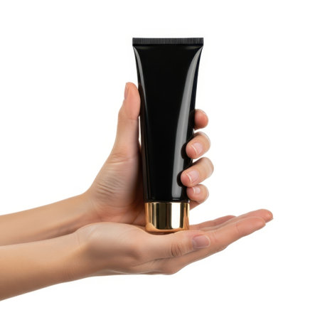 Hand holding black tube cosmetic product isolated on white backgroundの素材