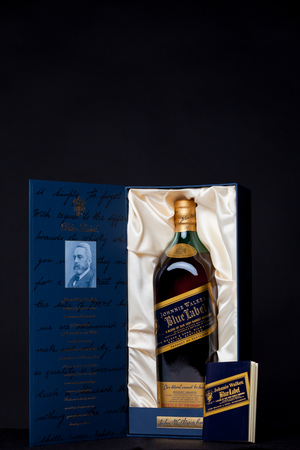 a "Johnnie Walker Blue Label" luxury numbered whiskey with box and papers in a display window on black Backgroundのeditorial素材