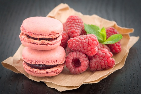 Macaroons with raspberries on a tableの写真素材