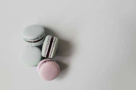 Top view of sweet French macaroon biscuits of pastel color lying on light grey background. Copy space.の写真素材