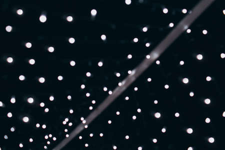 Night city lights blurred bokeh, dark background with a stripe.の写真素材