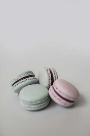Top view of a pile of sweet macaroon biscuits of pastel color lying on light grey background. Copy space.の写真素材
