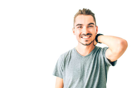 Happy young man smiling, holding one hand over his head on white isolated background.の写真素材
