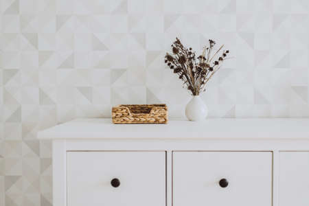 Stylish minimalistic space with dried flowers in a vase at home. Black and white colors, neutral background. Styled still life with copy space.の写真素材