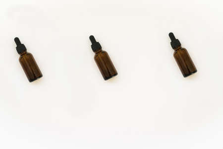 Homemade cosmetics glass bottles pattern. Natural medicine concept. Jars with essential oil isolated on a white background. Flat lay or top view.の写真素材
